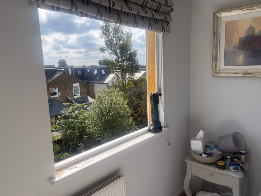 Sash window opening prepared during installation with a multi tool resting on the sill