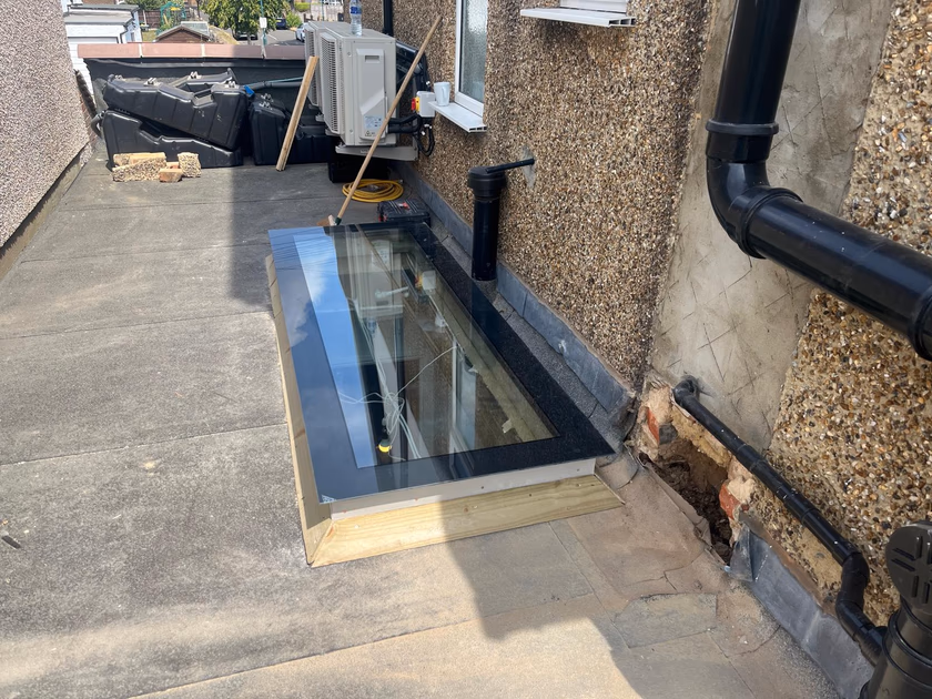 Flat glass rooflight sat down onto the new timber upstand on the flat roof