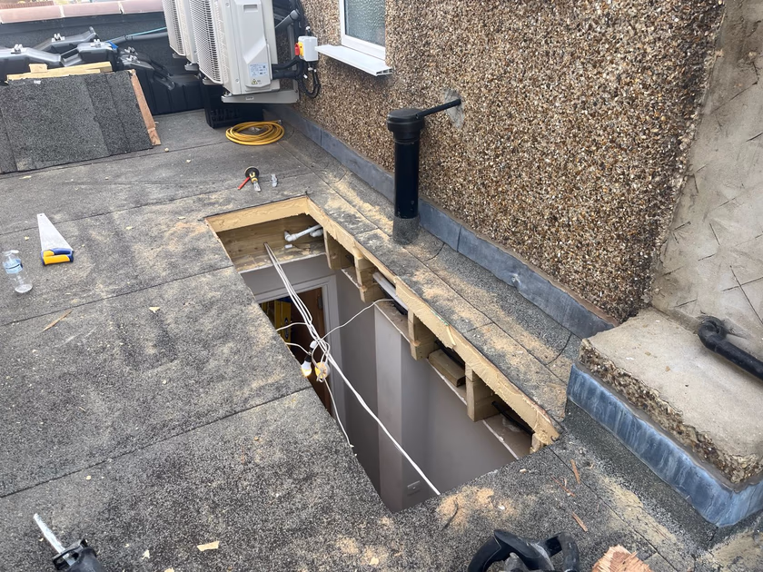 New rooflight opening cut through the flat roof deck, looking down into the hallway below