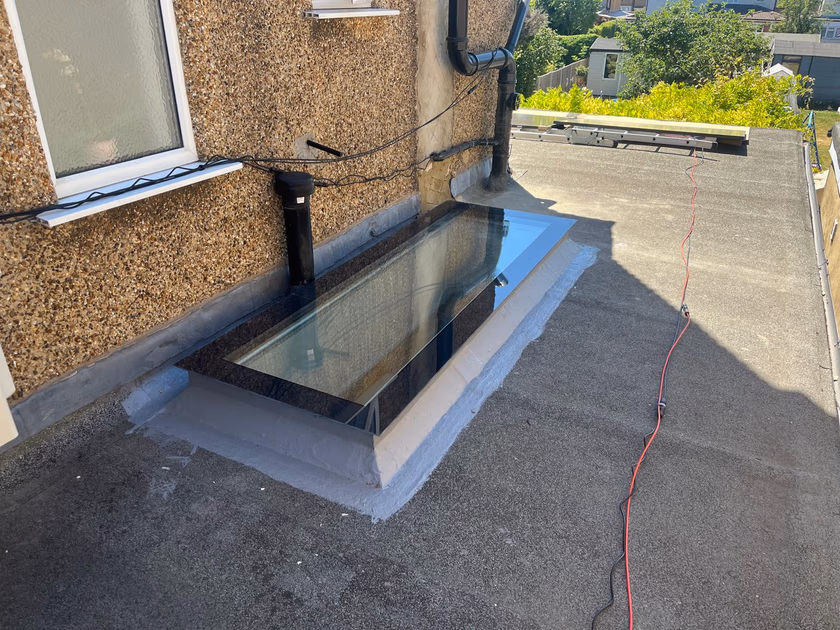 The completed flat glass rooflight weathered into the flat roof covering, seen in sunshine